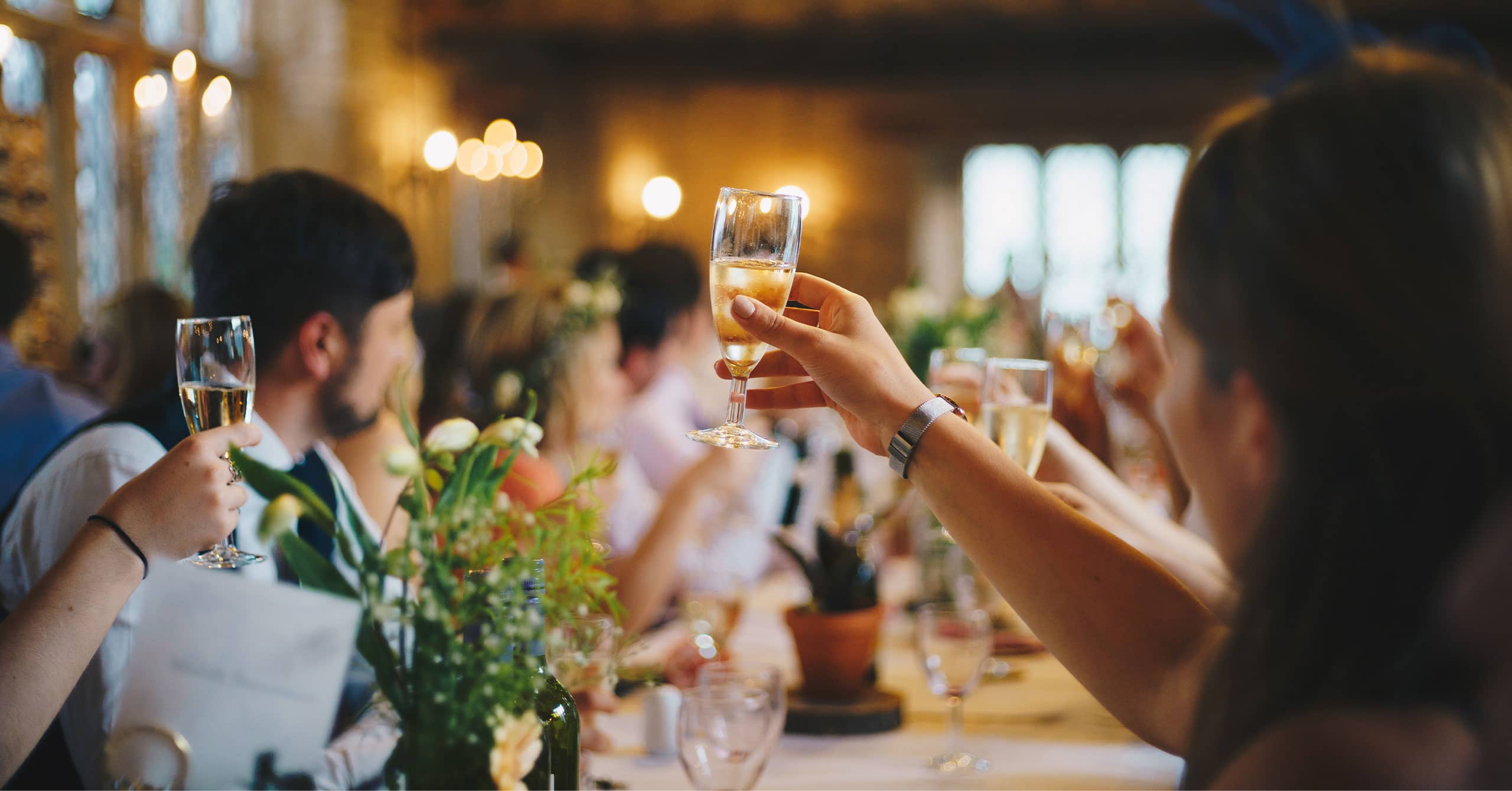A wedding guest holding a glass of champagne