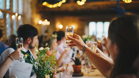 A wedding guest holding a glass of champagne